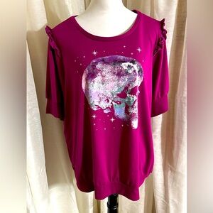 A torrid sweatshirt-like top with short sleeves, and a small ruffled shoulder.